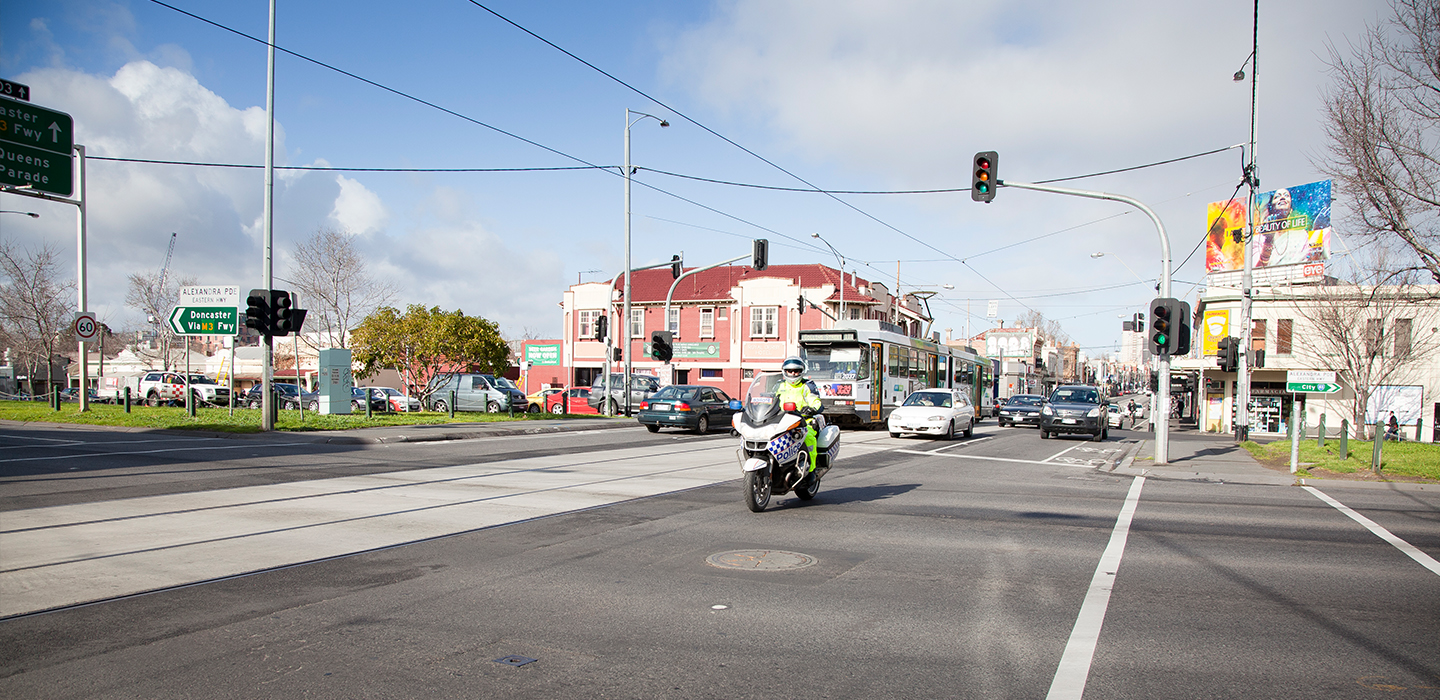 A main road with cars and a motorbike